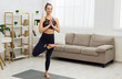 © Prostock-studio - Tree pose. Young woman doing yoga, relaxing at home