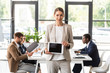 © LIGHTFIELD STUDIOS - front view of smiling beautiful businesswoman holding digital tablet with blank screen in office