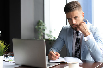 Wall Mural - Modern businessman thinking about something while sitting in the office