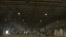 Aerial Drone Shot: Flying Inside An Anonymous Warehouse, Among Ready-to-ship Pallets Of Goods, Under Many Lamp Lights.