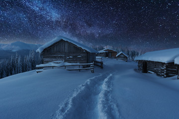 Wall Mural - Fairytale landscapes of the winter Carpathian Mountains with a charming milky way in the sky tourist tents and snowy houses in the valleys