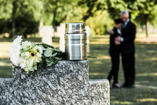 Selective Focus Of White Flowers And Cemetery Urn On Tombstone