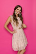 © studioloco - Smiling Beautiful Woman In Beige Lace Mini Dress Against Pink Background