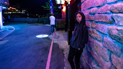 woman in hood jacket on street at night look cool , Purple and blue light , Jiufen , taiwan