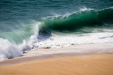Fototapeta Niebo - Beautiful crushing wave of Atlantic ocean, captured during the walk along the sandy beach in Nazare, Portugal