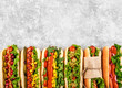 Six different hot dogs on a gray table, top view. Copyspace.
