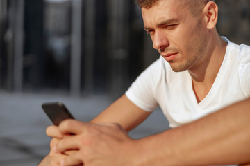 Focused attractive man looking at the smartphone