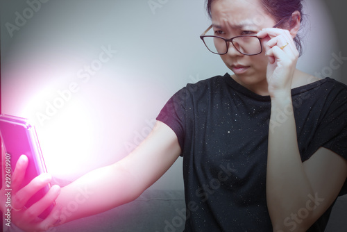 Fotomural Asian female trying to read something in her mobile phone with red spot on her hand