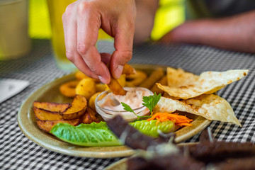 Canvas Print - man hand with plate with snacks on table background on bar or pub