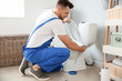 © Pixel-Shot - Plumber installing toilet in restroom