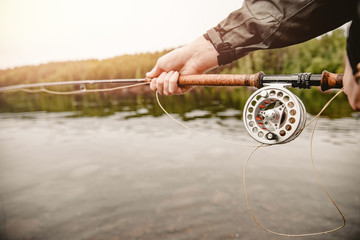 Wall Mural - Fisherman spool of rope using rod fly fishing in river