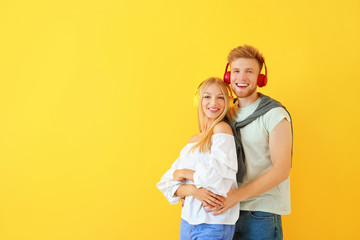 Sticker - Young couple listening to music on color background