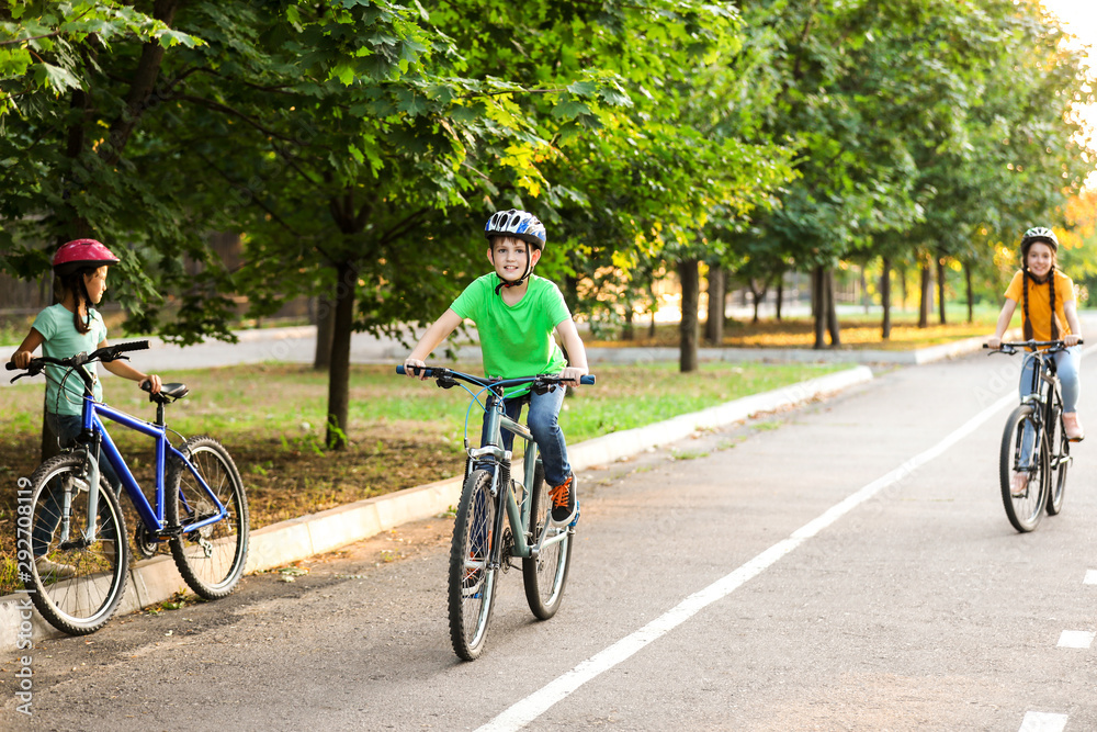 Cute children riding bicycles outdoors