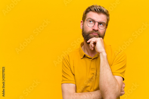 Fotografía young blonde man thinking, feeling doubtful and confused, with different options