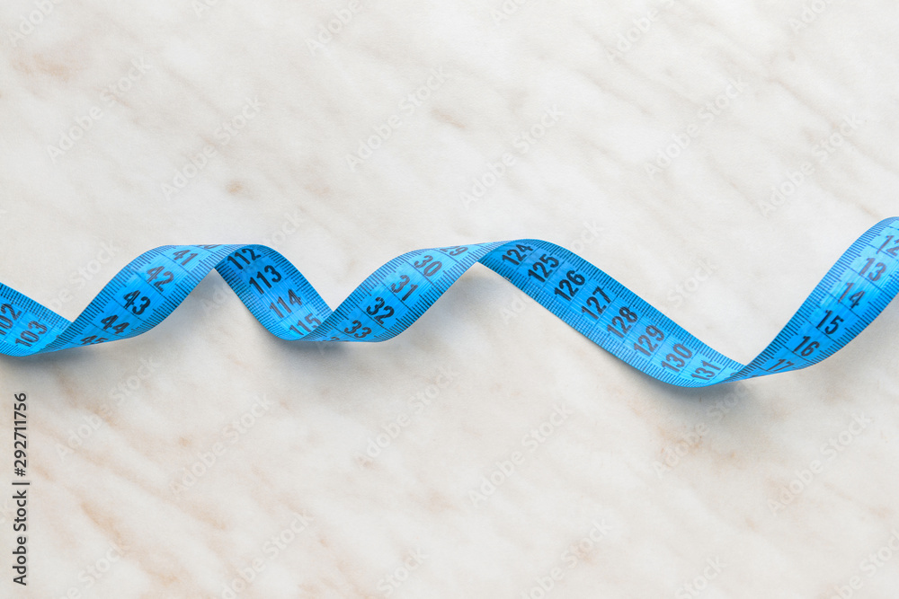 Measuring tape on light background