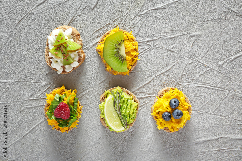 Different tasty sandwiches on grey background