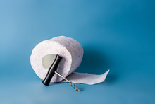 Constipation Concept. Roll Of Toilet Paper And A Corkscrew On Blue Background