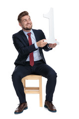 Poster - enthusiastic young businessman holding number one sign