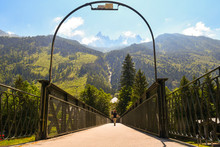 The Pedestrian Bridge Of The Railway Station With The Aiguilles De Chamonix Rocky Peaks In The Background In Summer, Chamonix-Mont-Blanc, Haute Savoie, France