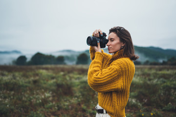 photographer traveler take photo on video camera closeup on background autumn foggy mountain, tourist shooting nature mist landscape outdoor, hobby adventure concept, copy space mockup