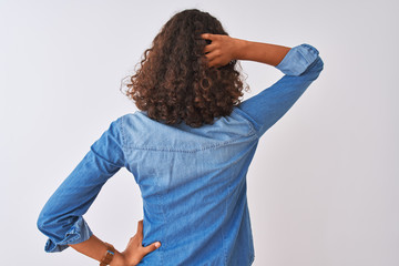 Wall Mural - Young brazilian woman wearing denim shirt standing over isolated white background Backwards thinking about doubt with hand on head