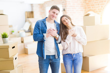 Poster - Beautiful young couple moving to a new house smiling with hands on chest with closed eyes and grateful gesture on face. Health concept.