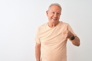 Senior grey-haired man wearing striped t-shirt standing over isolated white background doing happy thumbs up gesture with hand. Approving expression looking at the camera showing success.