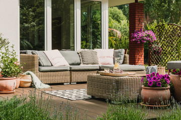 Classy furniture on wooden terrace in green beautiful garden