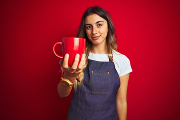 Poster - Young beautiful barista woman wearing apron over red isolated background with a confident expression on smart face thinking serious