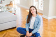 © Krakenimages.com - Beautiful young brunette woman smiling cheerful looking at the camera with a big smile on face sitting on the floor at home with sunlight at the background