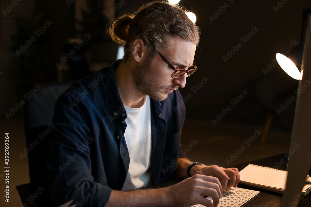 Man trying to meet deadline in office late in evening
