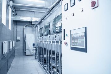 Wall Mural - Automatic washing machine conveyor with blue plastic bottles inside in water manufacturing factory