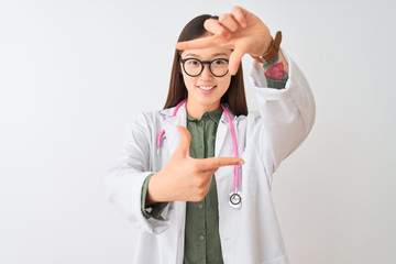 Young chinese dooctor woman wearing glasses stethoscope over isolated white background smiling making frame with hands and fingers with happy face. Creativity and photography concept.