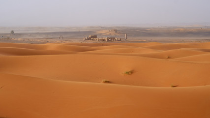 Abandoned ruins in Sahara desert, landscape with a beautiful sand dunes in Morocco.            