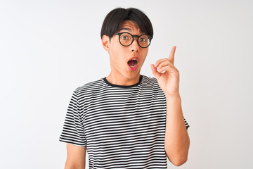 Wall Mural - Chinese man wearing glasses and navy striped t-shirt standing over isolated white background pointing finger up with successful idea. Exited and happy. Number one.