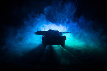 War Concept. Armored vehicle silhouette fighting scene on war foggy sky background at night. American tank ready to fight.