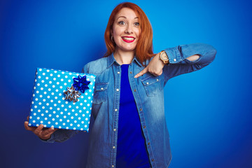 Sticker - Young beautiful redhead woman wearing birthday gift over isolated blue background with surprise face pointing finger to himself