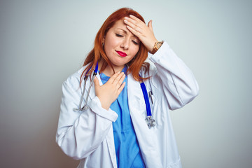 Wall Mural - Young redhead doctor woman using stethoscope over white isolated background Touching forehead for illness and fever, flu and cold, virus sick