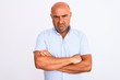 © Krakenimages.com - Middle age handsome man wearing casual shirt standing over isolated white background skeptic and nervous, disapproving expression on face with crossed arms. Negative person.