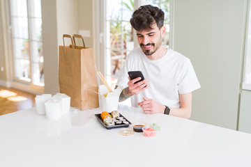 Sticker - Young man eating asian sushi from home delivery and ordering food using smartphone app with a happy face standing and smiling with a confident smile showing teeth