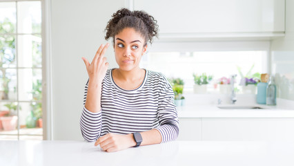 Sticker - Beautiful african american woman with afro hair wearing casual striped sweater Shooting and killing oneself pointing hand and fingers to head like gun, suicide gesture.