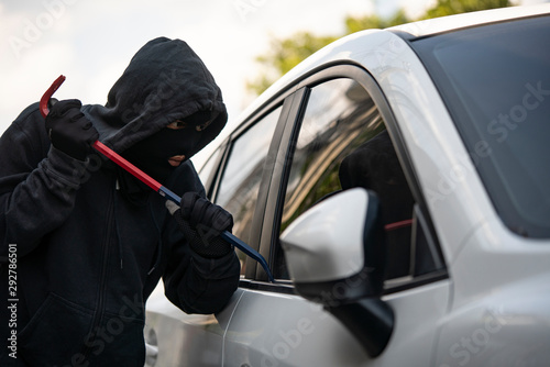 Fotografía Auto thief in black balaclava trying to break into car