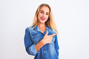 Young beautiful woman wearing casual denim shirt standing over isolated white background cheerful with a smile on face pointing with hand and finger up to the side with happy and natural expression