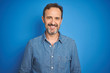 © Krakenimages.com - Handsome middle age senior man with grey hair over isolated blue background with a happy and cool smile on face. Lucky person.