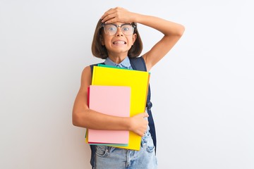 Poster - Beautiful student child girl wearing backpack glasses books over isolated white background stressed with hand on head, shocked with shame and surprise face, angry and frustrated. Fear and upset.