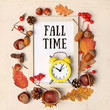 Fall time. Autumn composition with white frame and retro alarm clock, autumnal leaves, acorns, cones, berries. fall harvest season, thanksgiving day concept. Flat lay. close up
