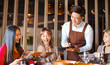 © Tom Wang - Handsome young waiter  taking an order  in hot pot reataurant