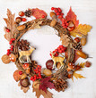 autumn Thanksgiving wreath with deer family toy, fall leaves, red berries, acorns on light background. autumn holiday, thanksgiving, halloween concept. Flat lay, top view