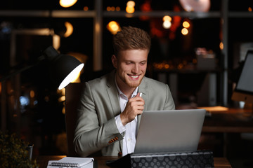 Poster - Young man working in office at night