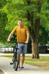 Wall Mural - Handsome man with modern bicycle in park